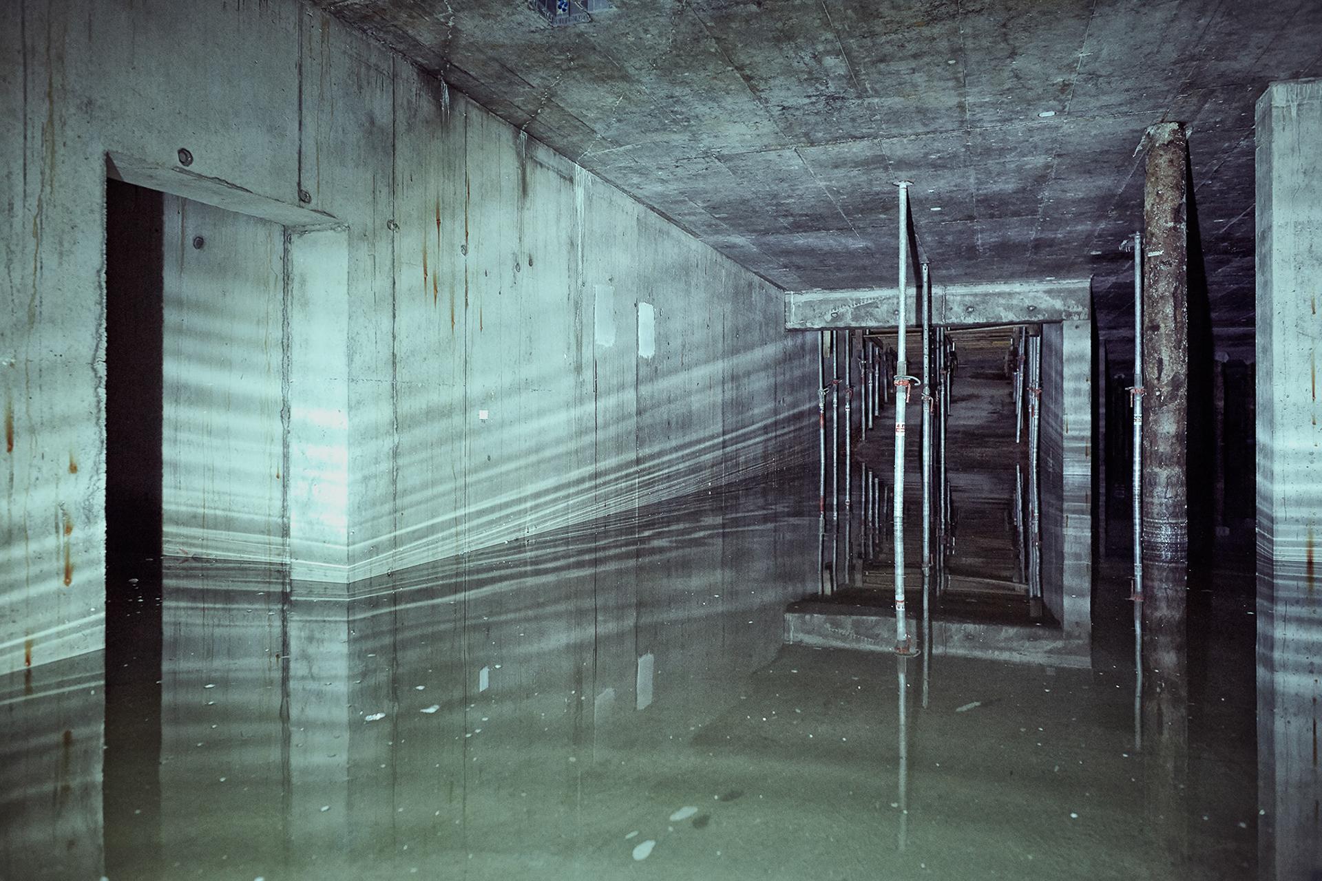 In einer Baustelle: Ein geflutetes Haus mit Betonwänden und Betondecken.