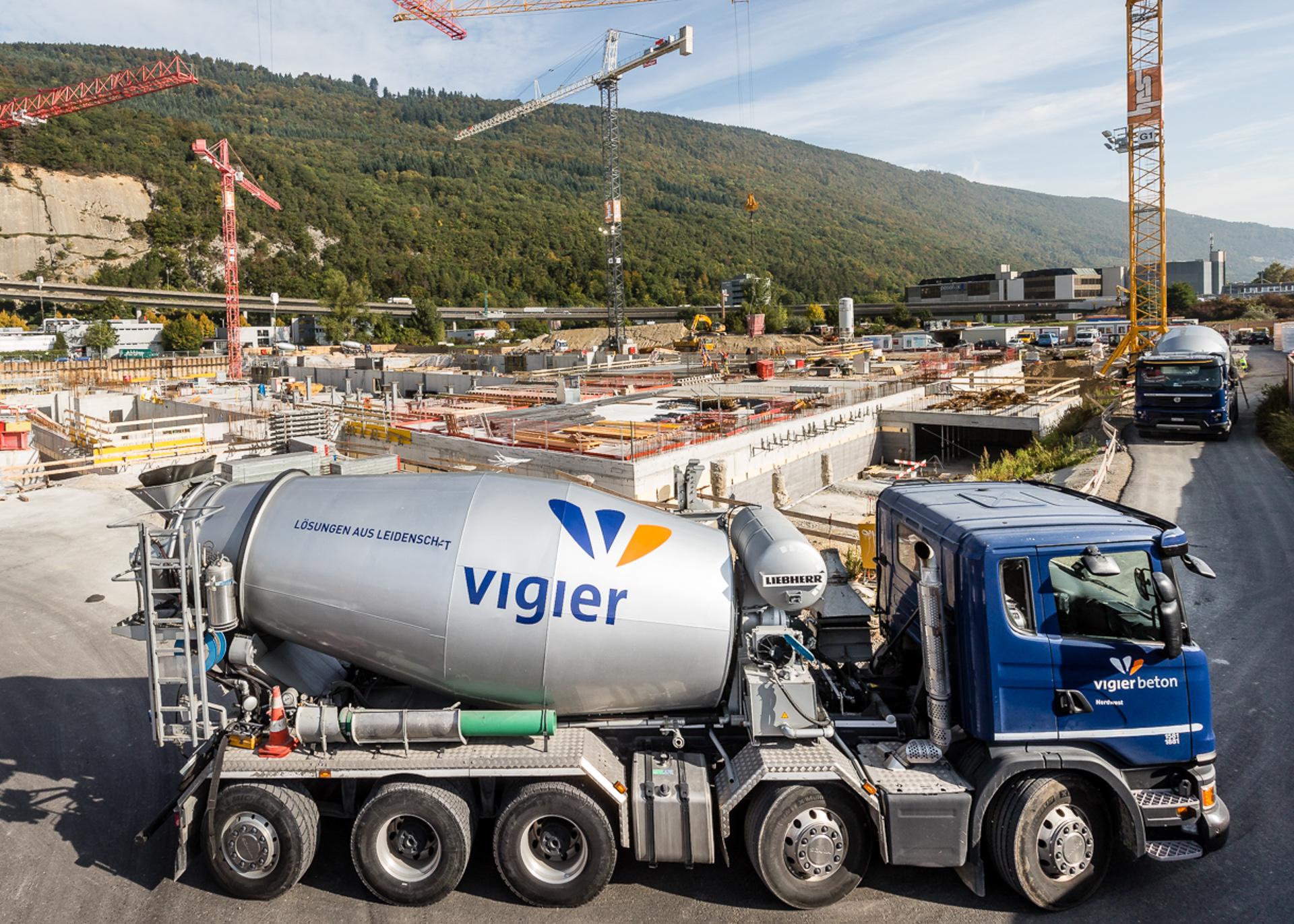 Eine Baustelle in Biel: Im Vordergrund ein Betonmischer von Vigier Beton. Im Hintergrgund der grüne Jura.